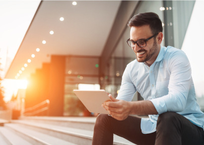 Smiling man using a tablet outside on his patio