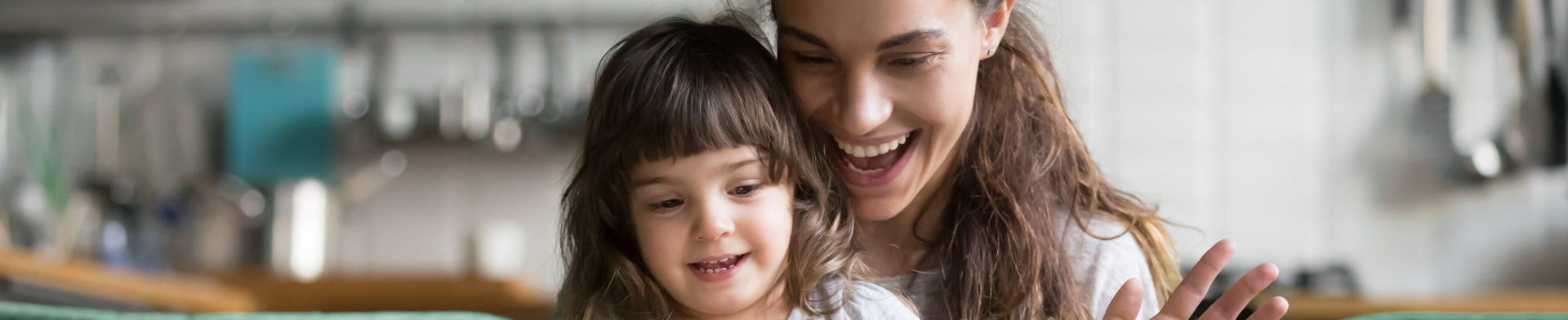 A mother and child smiling down at a book.