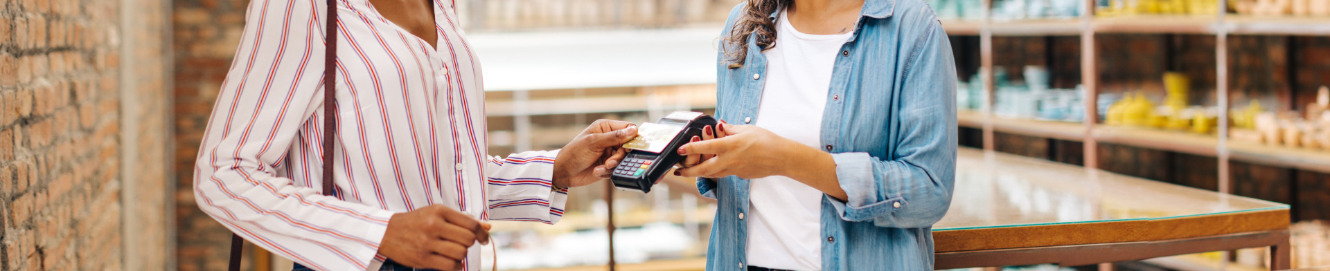 A person using their debit card on a using a card point of sale machine.