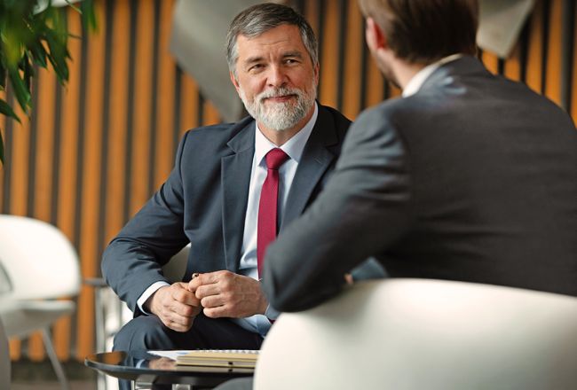 Two business men sit and talk 