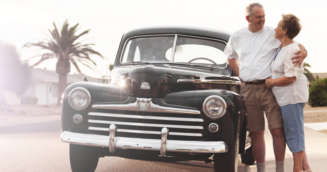 Couple hugging next to their vintage truck 